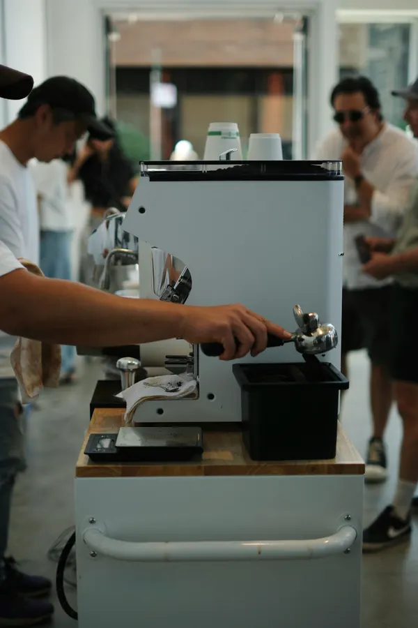 A barista preparing coffee at the machine
